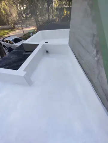 Terraza con membrana blanca y rejilla.