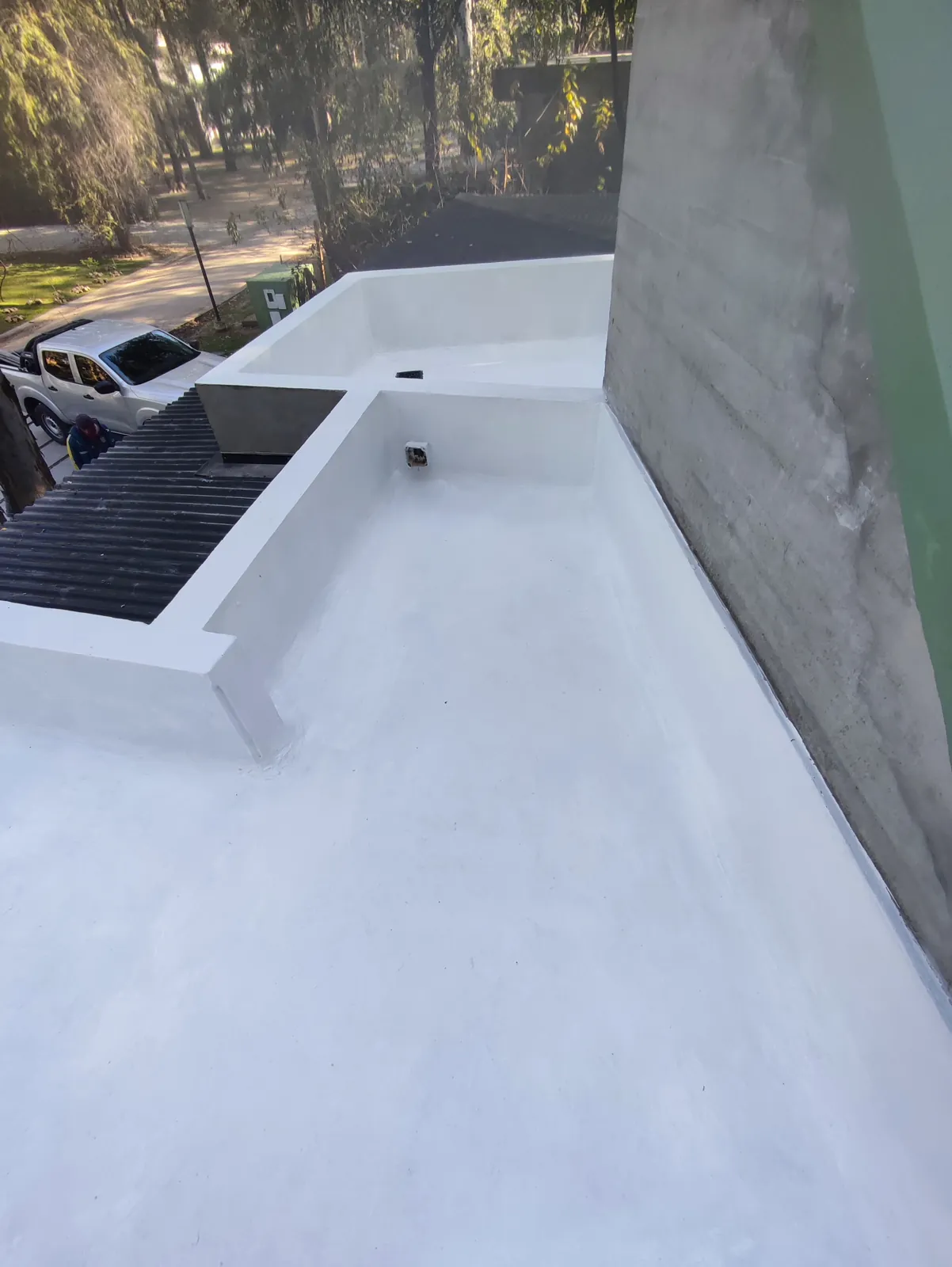 Terraza con membrana blanca y rejilla.