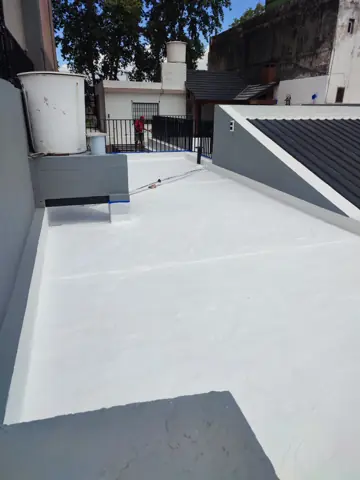 Terraza con membrana blanca y tanque de agua.