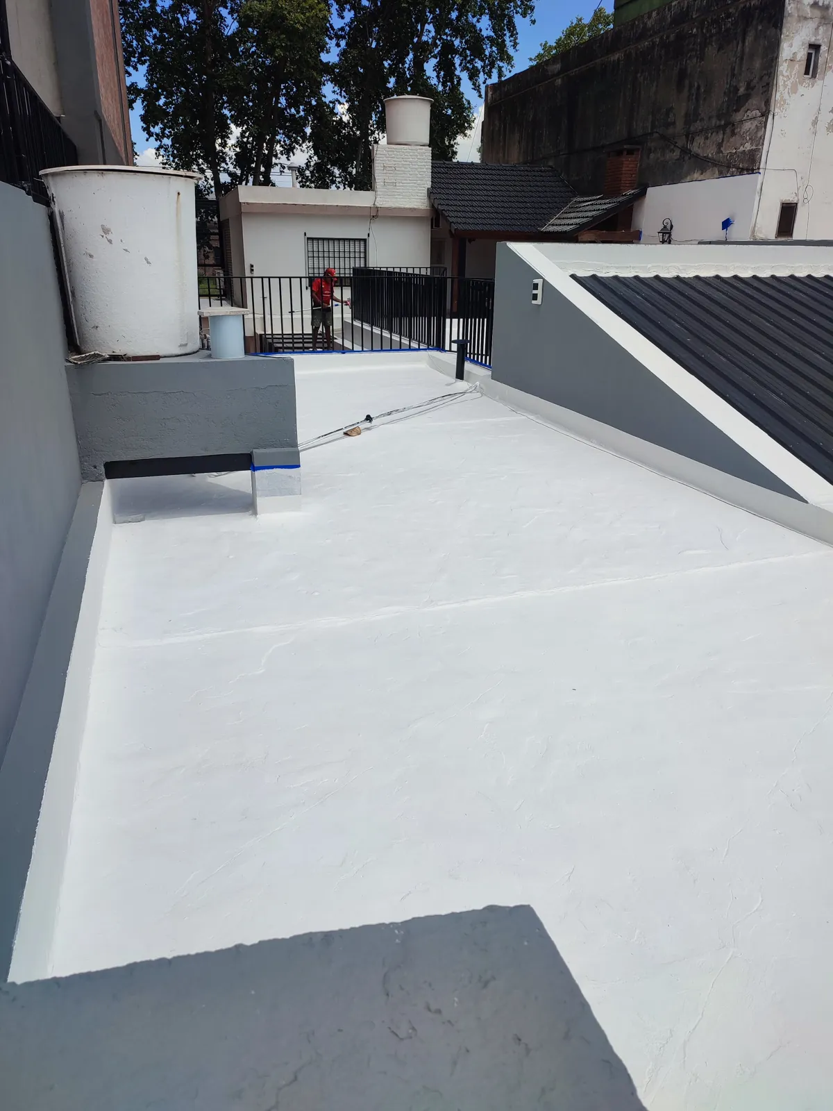 Terraza con membrana blanca y tanque de agua.