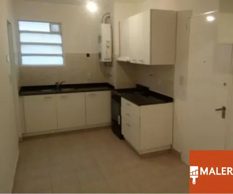Cocina terminada con paredes y muebles blancos.