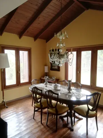 Comedor con paredes amarillas y techo de madera.