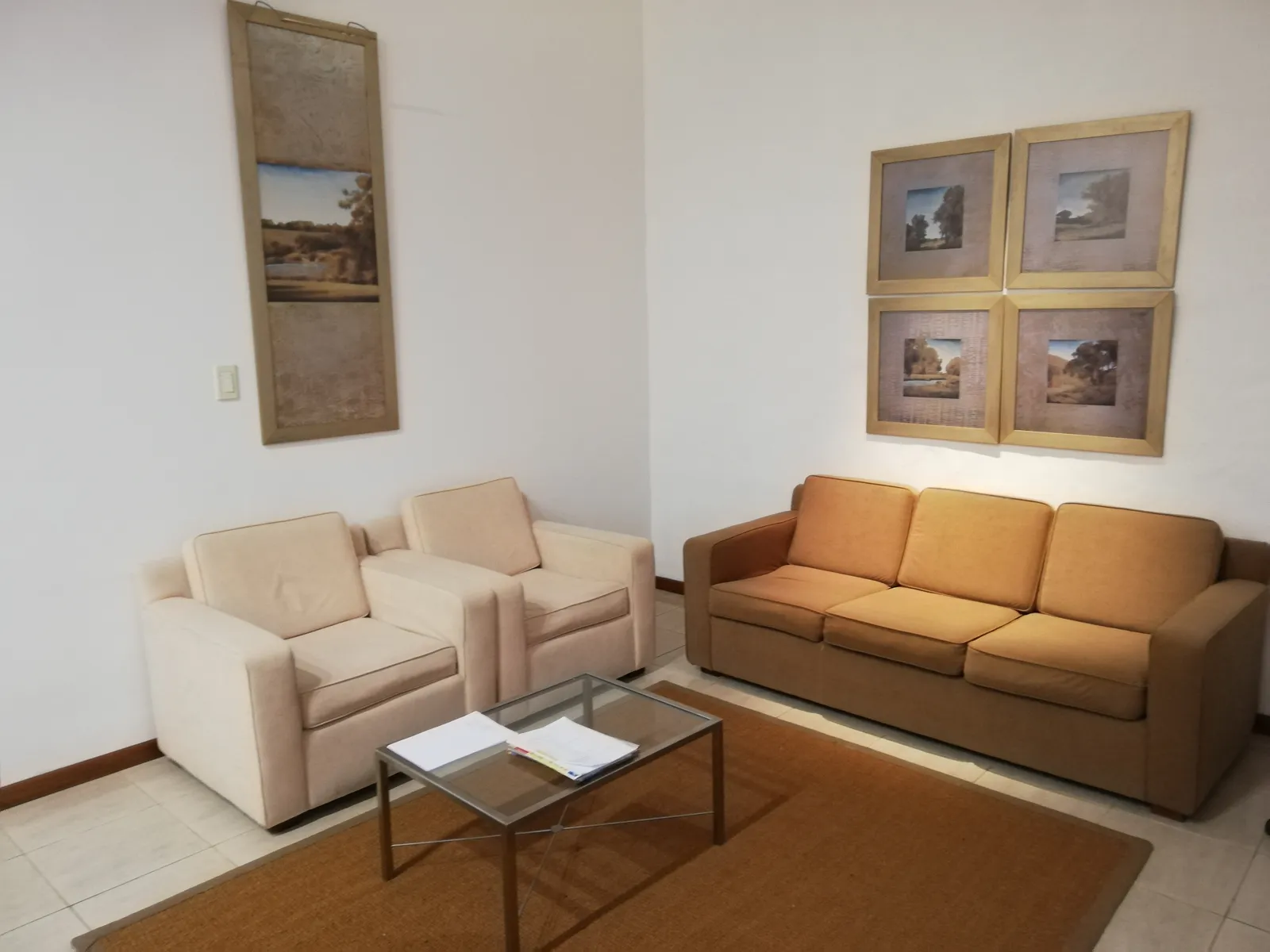 Sala de espera con paredes claras y sillones.