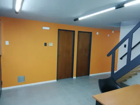 Oficina con pared naranja y puertas de madera.