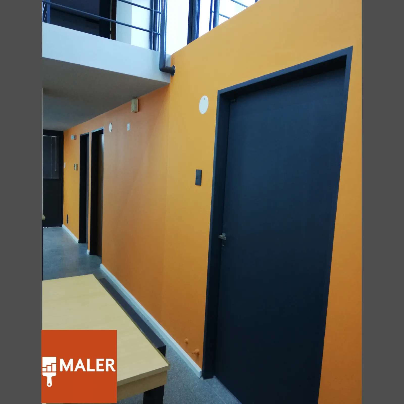 Pasillo con pared naranja y puerta azul.