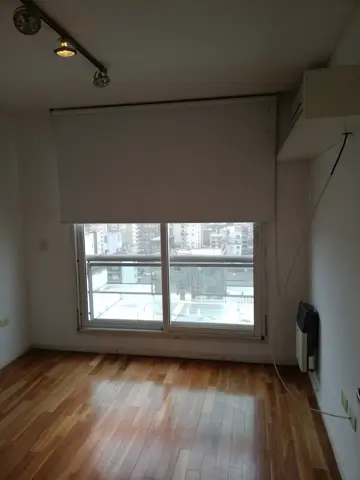 Ambiente pintado de blanco con ventana al balcón.