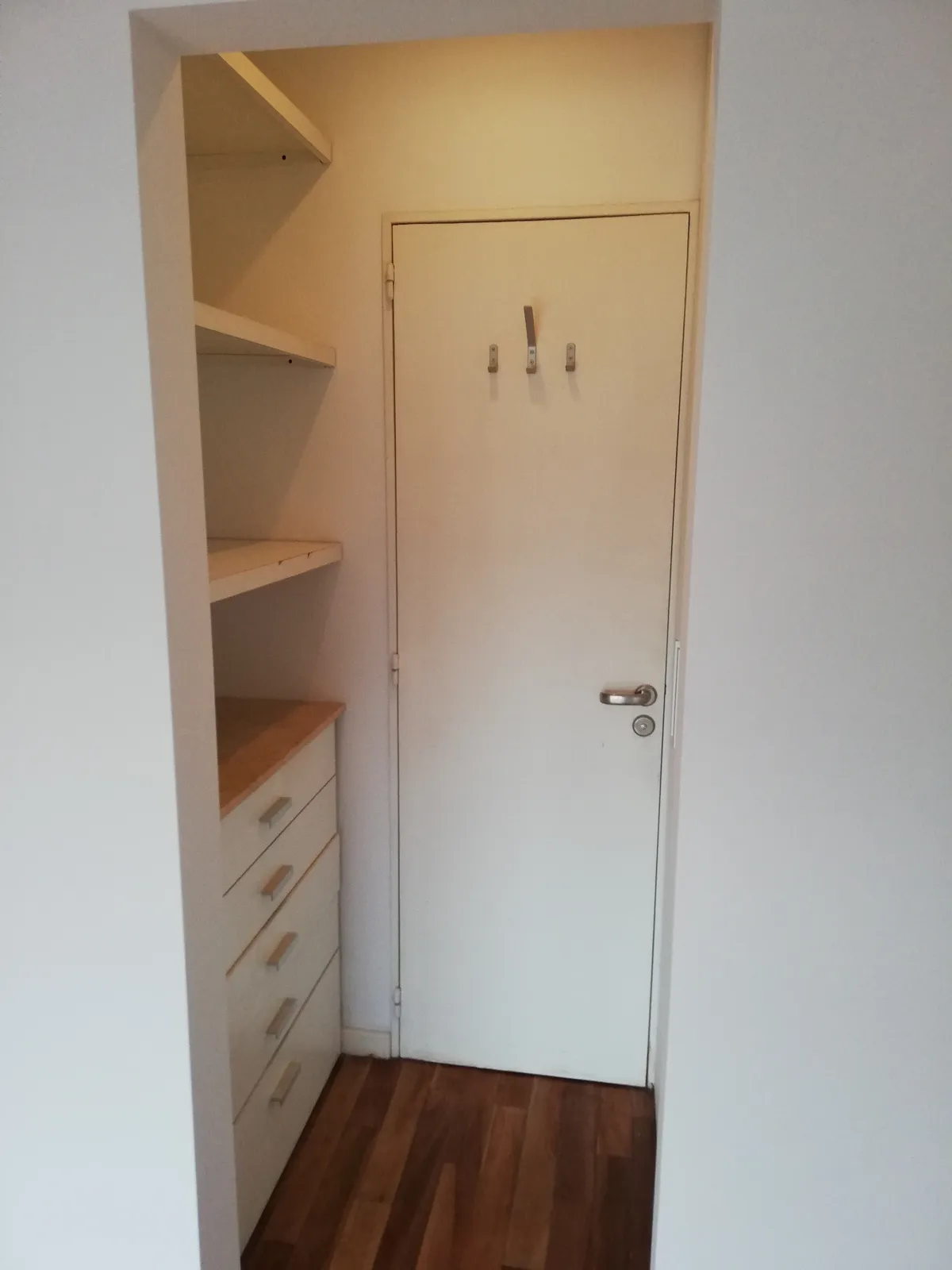 Vestidor con placard, paredes pintadas de blanco.