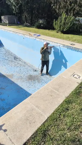 Operario preparando el fondo de la pileta azul.