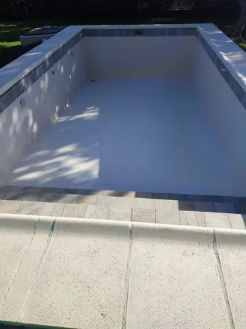Pileta vacía con línea de venecitas en el borde.