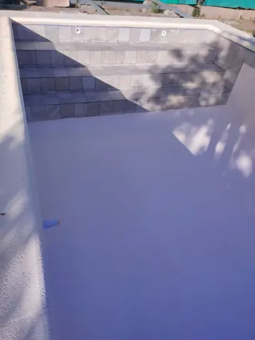 Pileta vacía con escalera de venecitas.