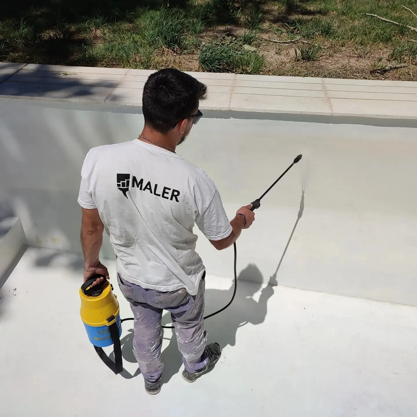 Operario de Maler limpiando una pileta con hidrolavadora.