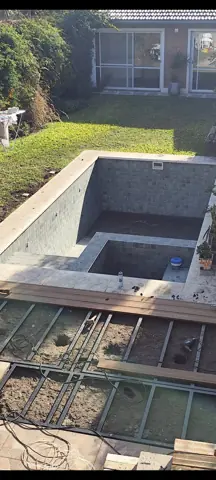 Pileta en obra con estructura de deck alrededor.