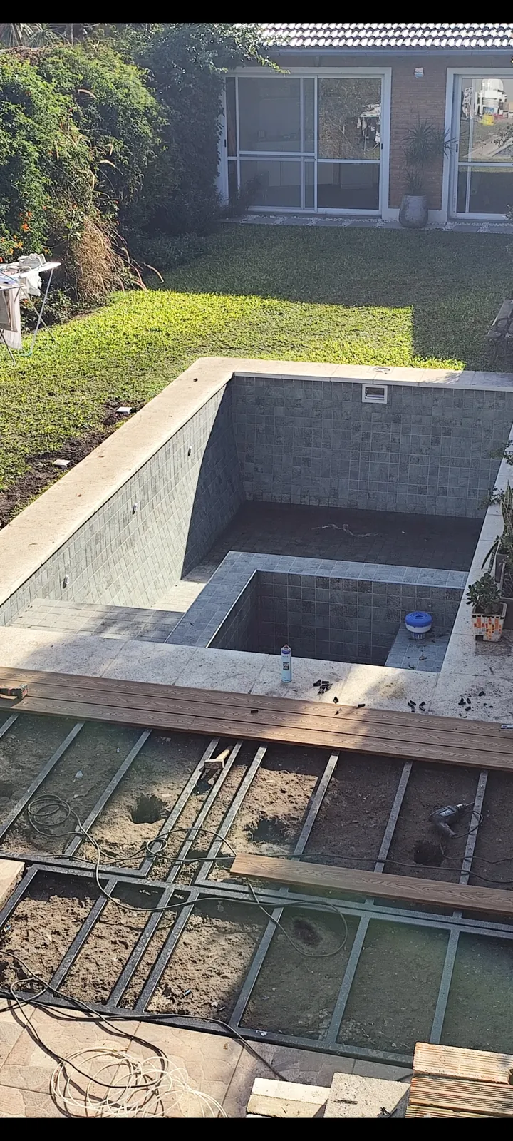 Pileta en obra con estructura de deck alrededor.